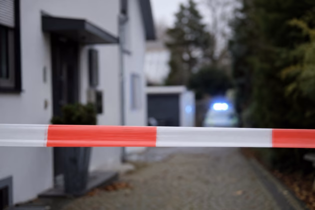 Symbolbild: Polizeiabsperrung vor einem Wohnhaus. Foto: KI-generiert